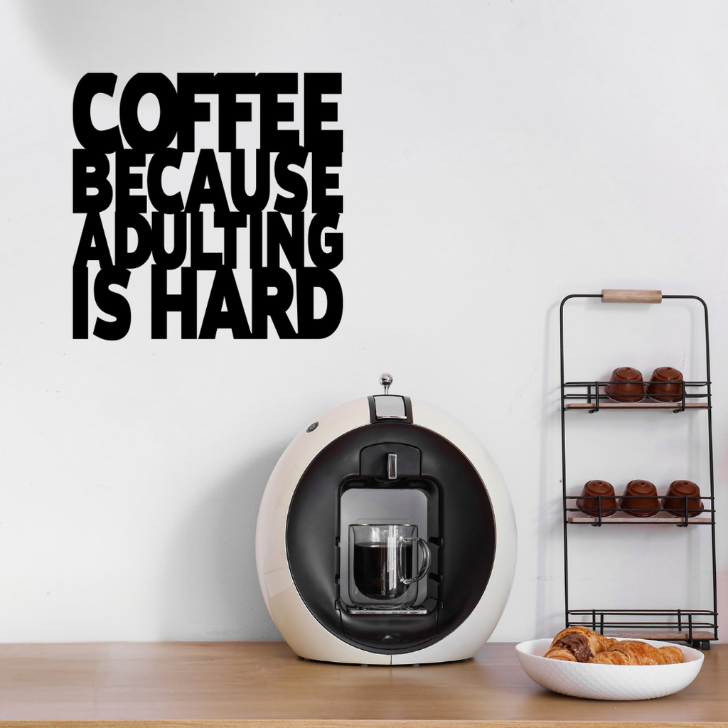 Coffee Because Adulting Is Hard | Funny Coffee Metal Wall Art showcased above a stylish home coffee station with an espresso machine and coffee accessories.