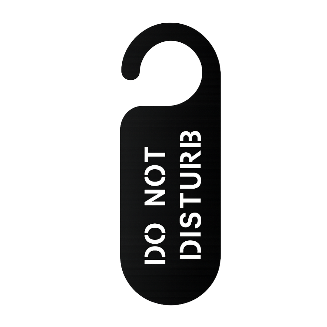 Close-up of the laser-cut Do Not Disturb metal door hanger sign with minimalist typography and matte black finish.