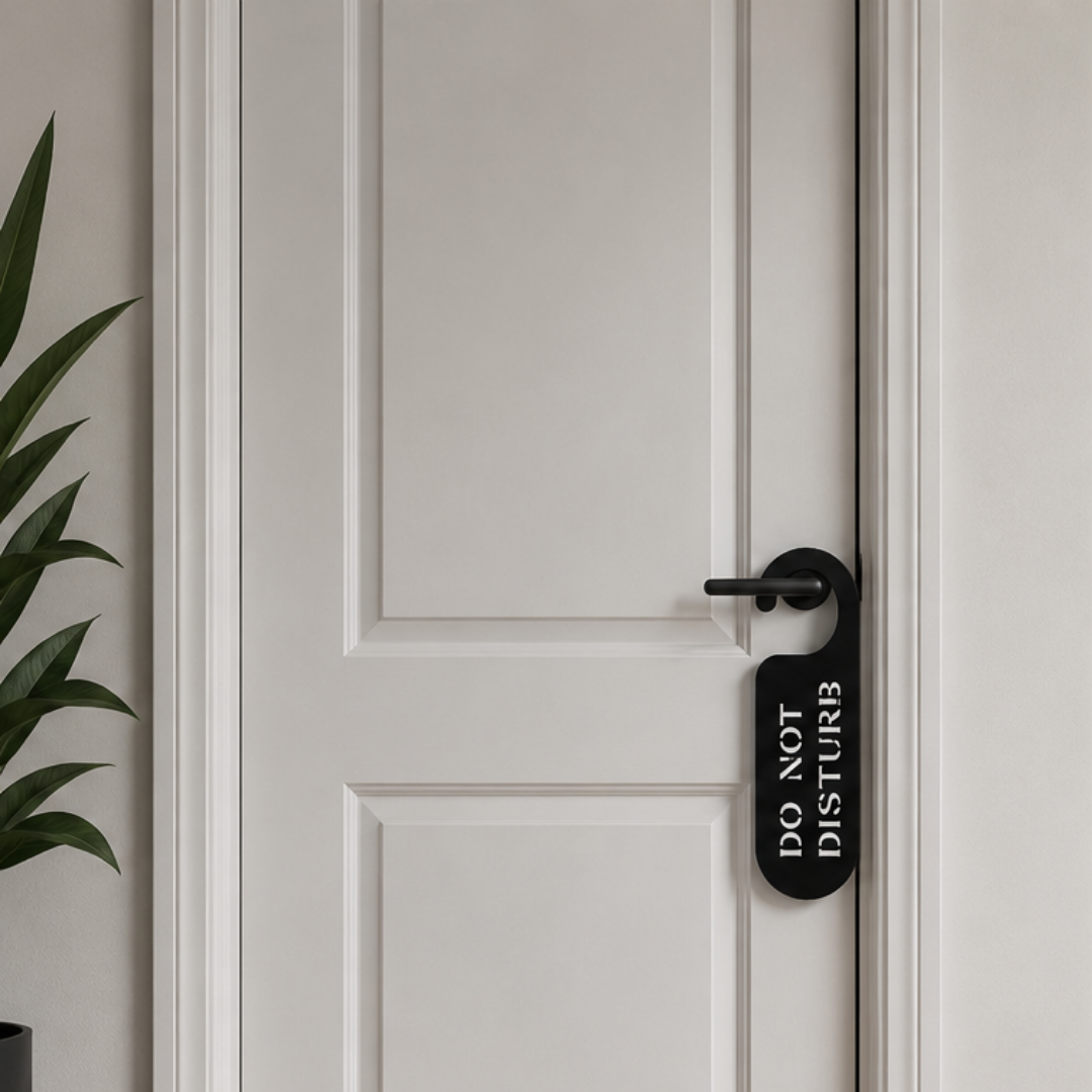 Do Not Disturb metal door hanger sign hanging from a white interior door, providing a stylish privacy solution for bedrooms, hotels, or offices.