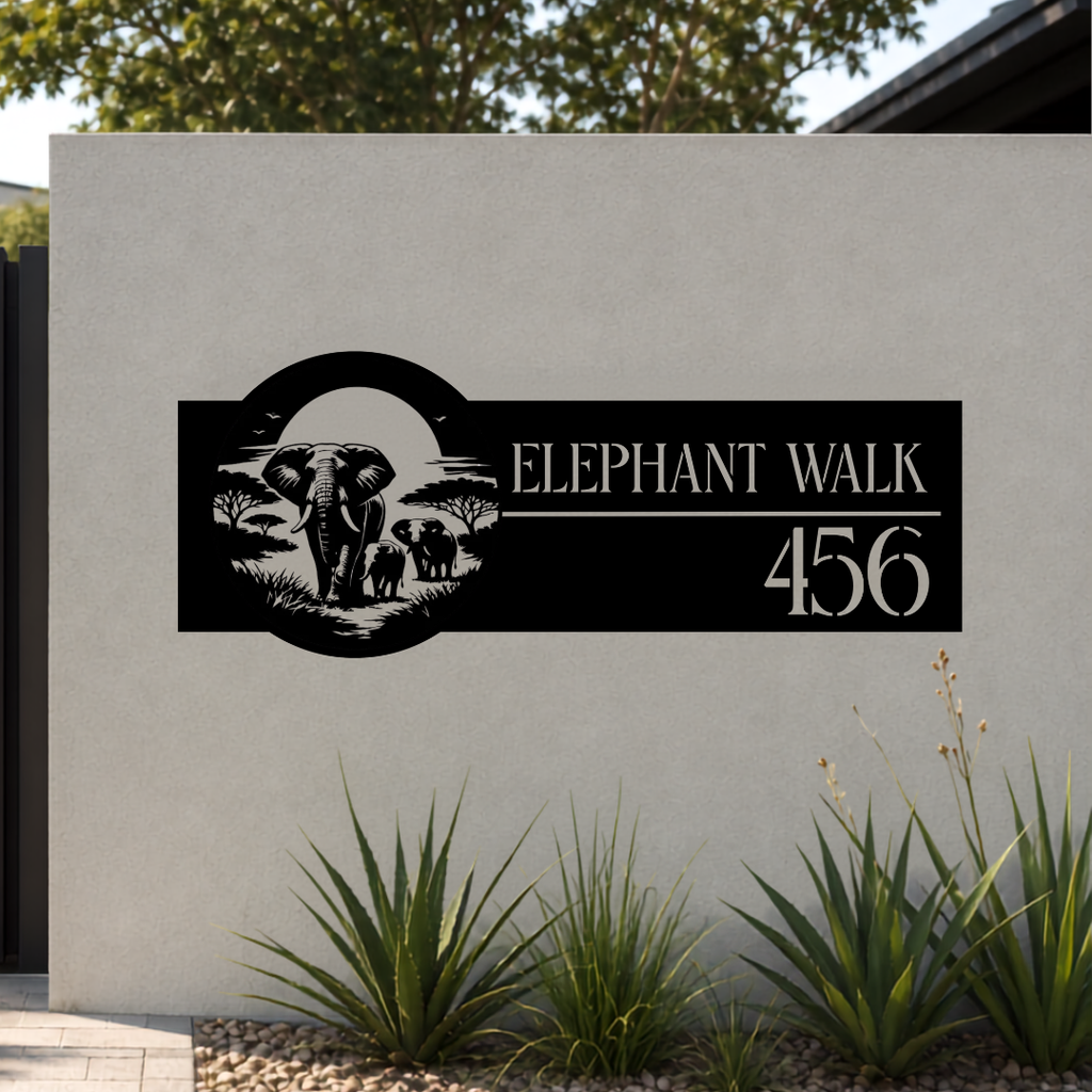 Elephant Walk safari metal house number sign mounted on a modern rendered boundary wall with landscaped garden.