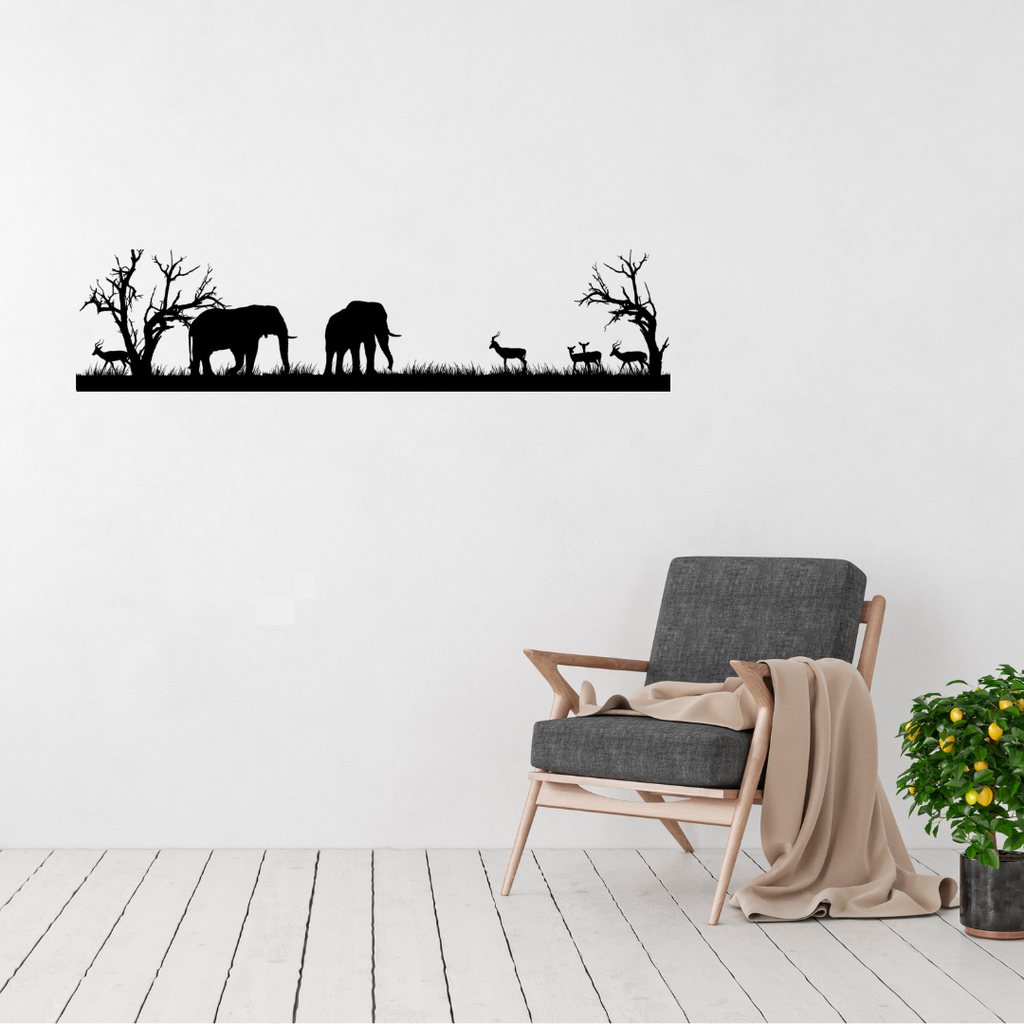 African savanna silhouette metal wall art featuring elephants, impala and bare African trees over contemporary chair.