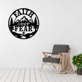 Faith Above Fear mountain cross metal wall art displayed above a contemporary chair in a modern interior