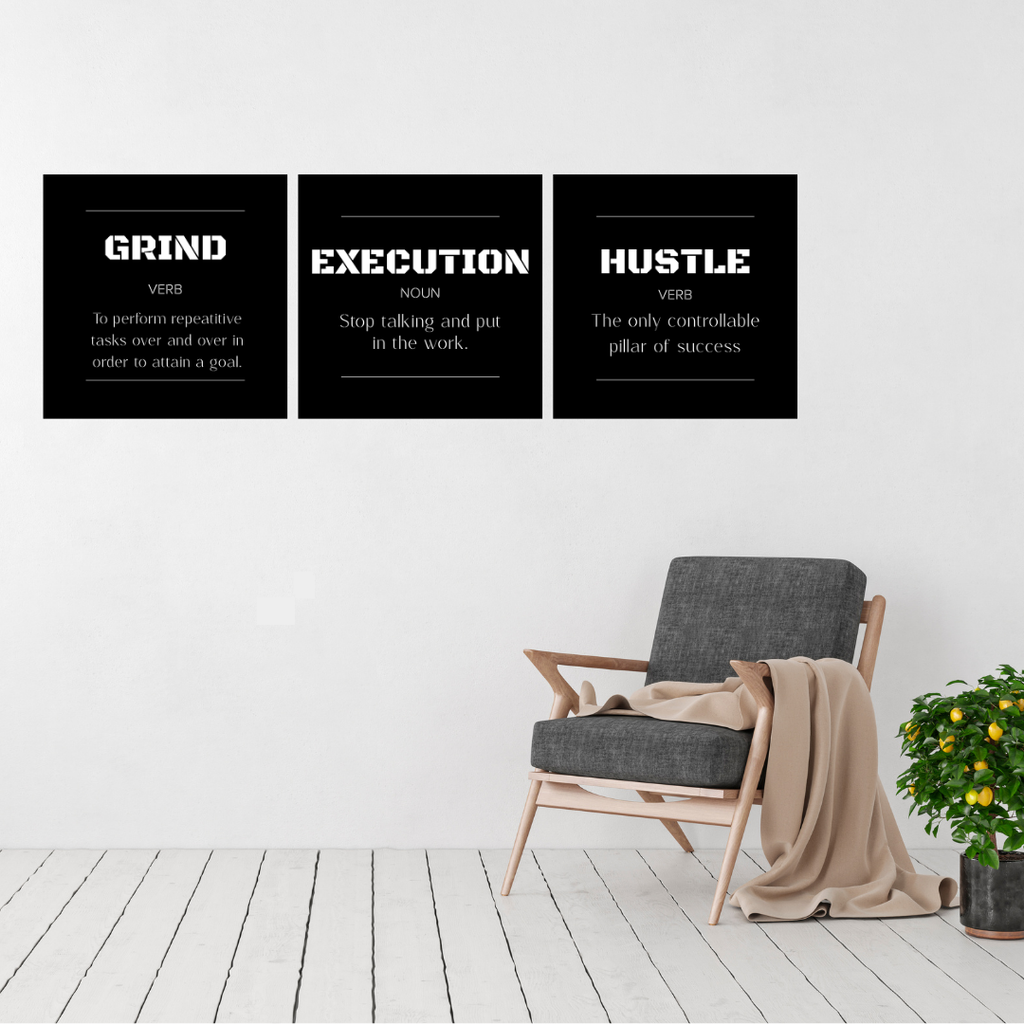 Grind • Execution • Hustle | Motivational Metal Wall Art Set (3 Piece) displayed on a modern white wall above a contemporary armchair.