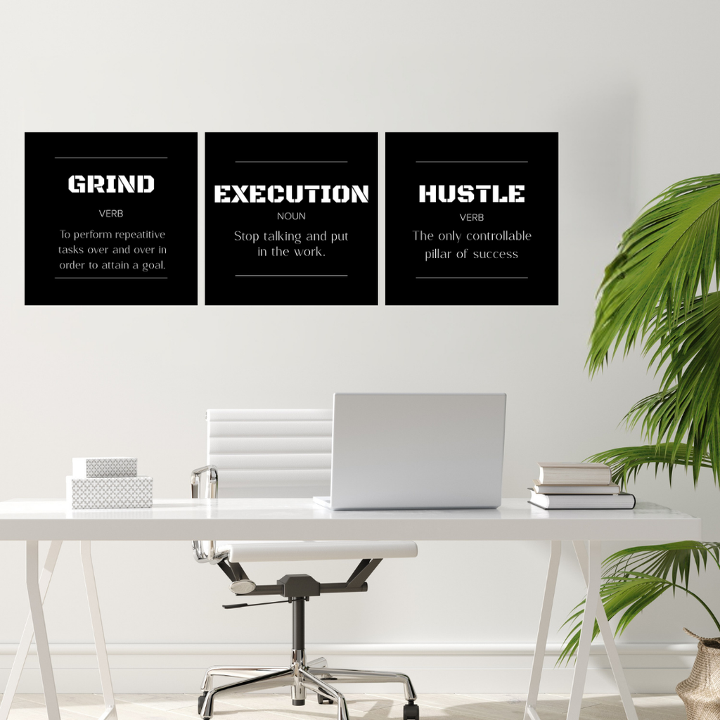 Grind • Execution • Hustle | Motivational Metal Wall Art Set (3 Piece) showcased above a modern office desk with a laptop, books, and indoor plants.