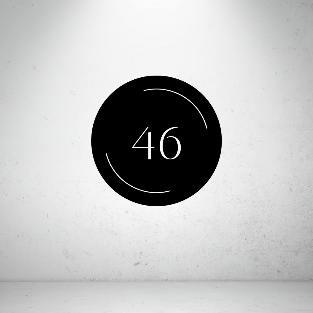 Modern circular metal house number sign with minimalist arc detailing and a custom house number.