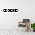 Heart of Home | HOME Horizontal Metal Wall Sign displayed in a bright modern living room.