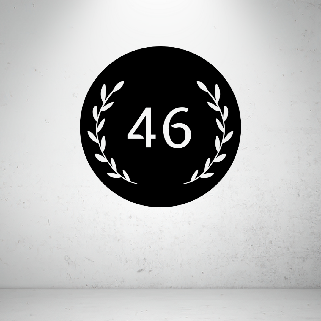 Circular metal house number sign with decorative botanical leaf detailing and a custom house number.