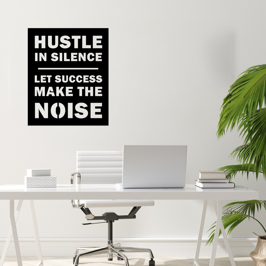 Motivational metal wall art displayed above a contemporary office workspace.
