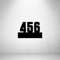 Industrial floating metal house number sign featuring bold laser-cut numbers mounted on a solid horizontal base.