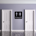 Toilet Sign | Male & Female Restroom Sign displayed on a modern restroom wall between two white doors.