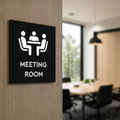 Modern black Meeting Room metal door sign mounted on a wooden office door featuring a meeting icon and clean typography.