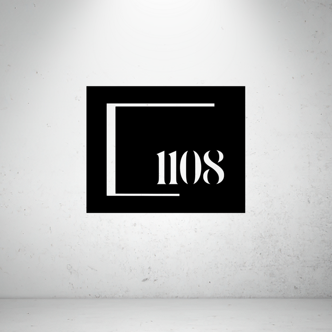 Modern framed metal house number sign featuring a custom address number within a minimalist open-frame design.