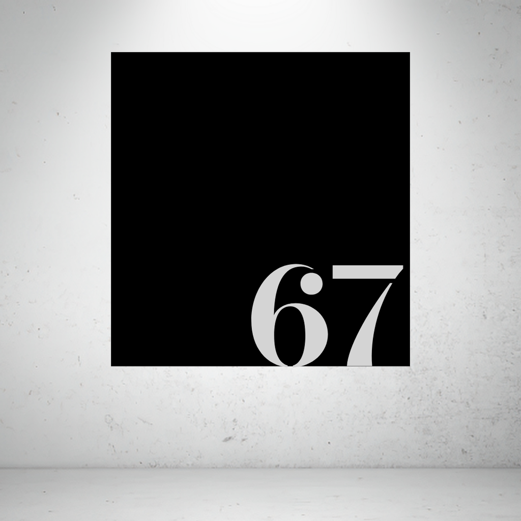 Metal house number sign with oversized modern numbers on a grey background