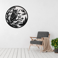 Moonlit Wisdom | Owl Circular Metal Wall Art displayed on a modern living room wall above a grey accent chair, featuring a detailed owl perched on a tree branch beneath a full moon with mountains and pine trees in black metal.