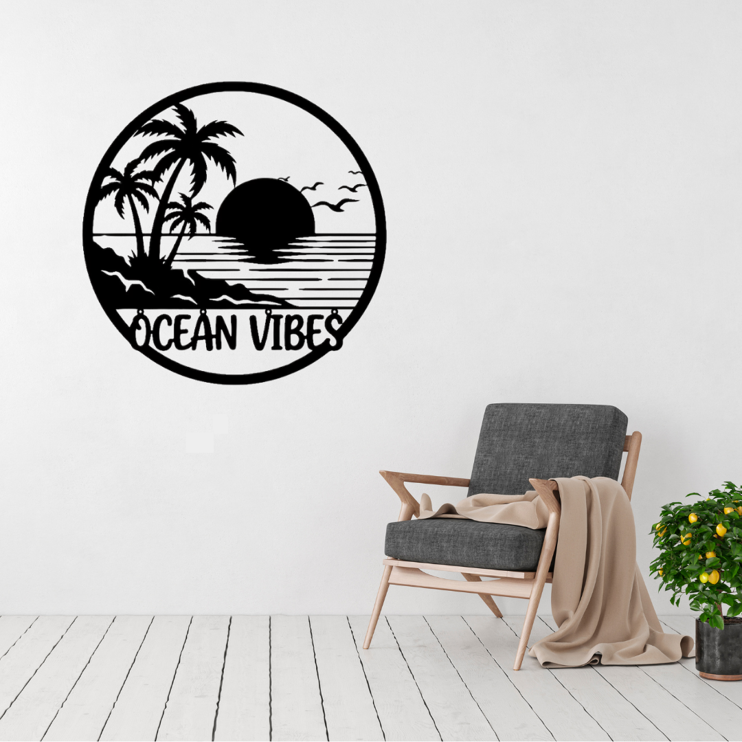 Ocean Vibes | Tropical Sunset Metal Wall Art displayed in a modern living room, featuring a tropical beach sunset with palm trees, ocean waves and the Ocean Vibes lettering in a circular black metal wall art design.