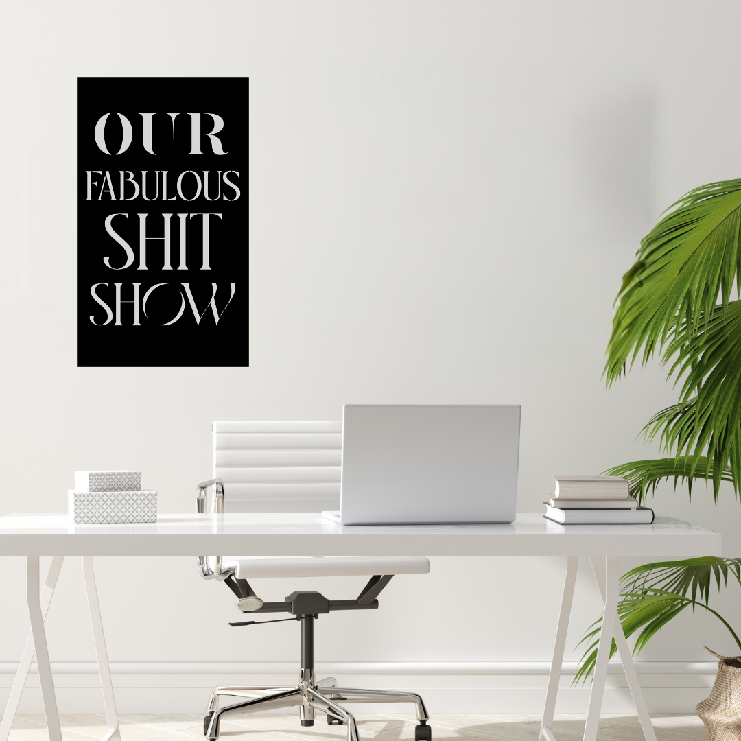 Funny office typography metal wall art mounted above a modern desk in a bright home office workspace.