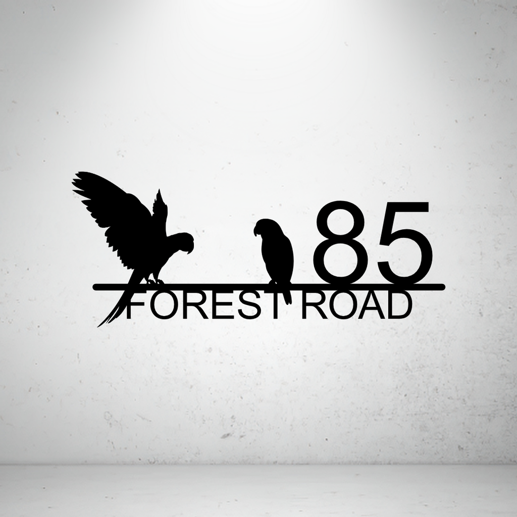 Metal house number sign with parrot silhouettes on a grey background