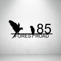 Metal house number sign with parrot silhouettes on a grey background