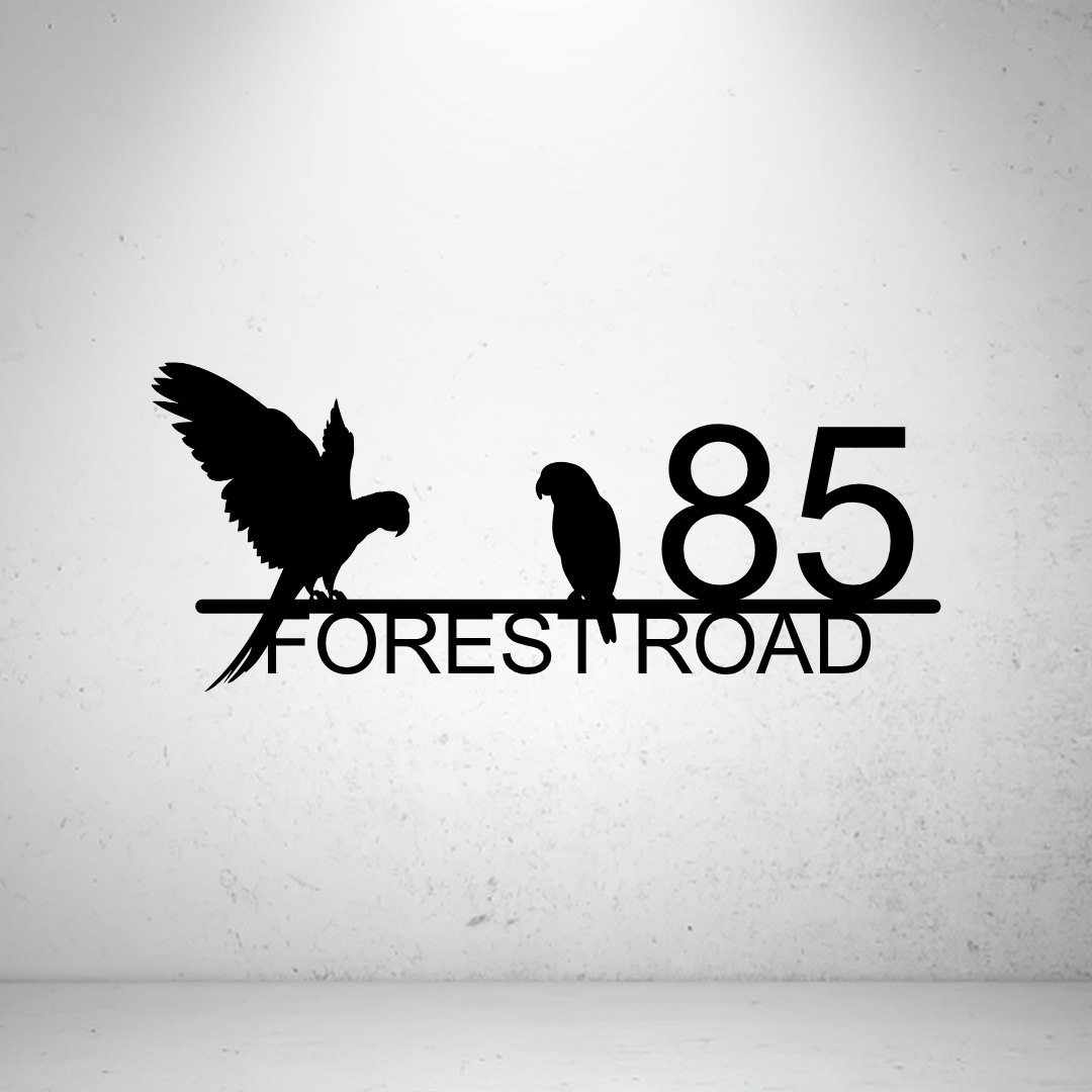 Metal house number sign with parrot silhouettes on a grey background