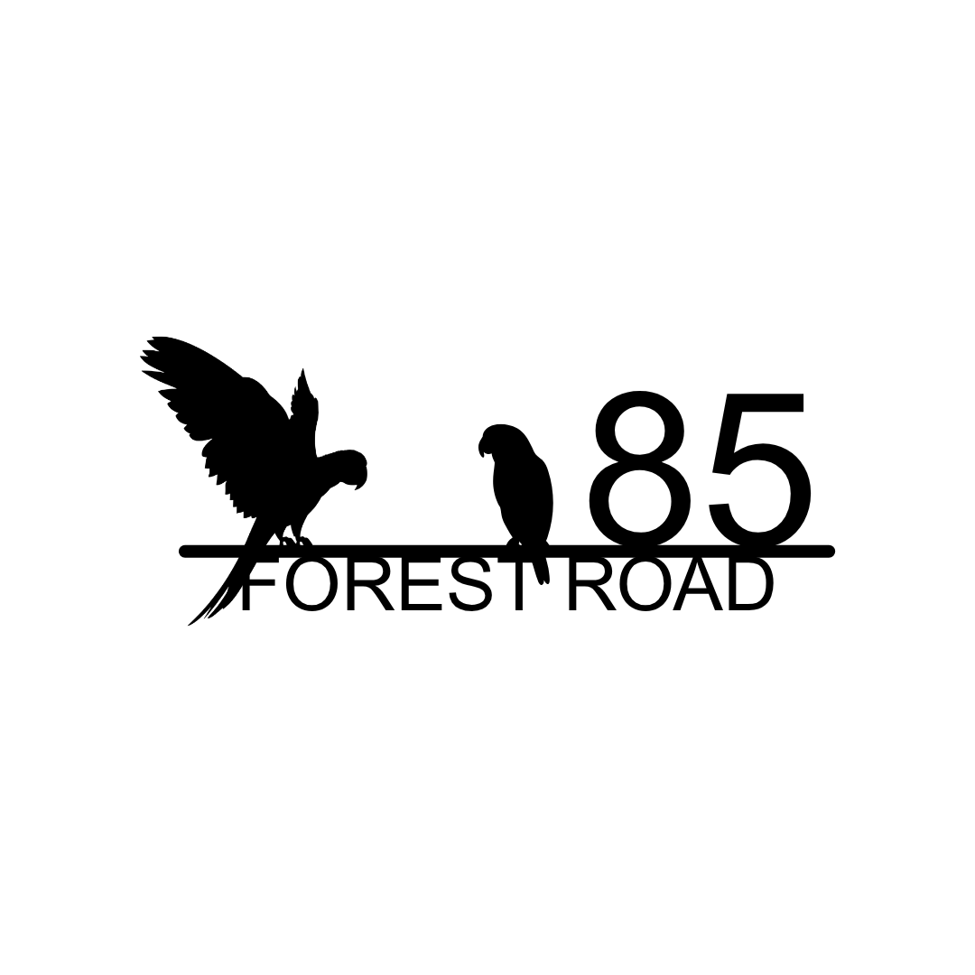 Metal house number plaque isolated on a plain white background with tropical bird design