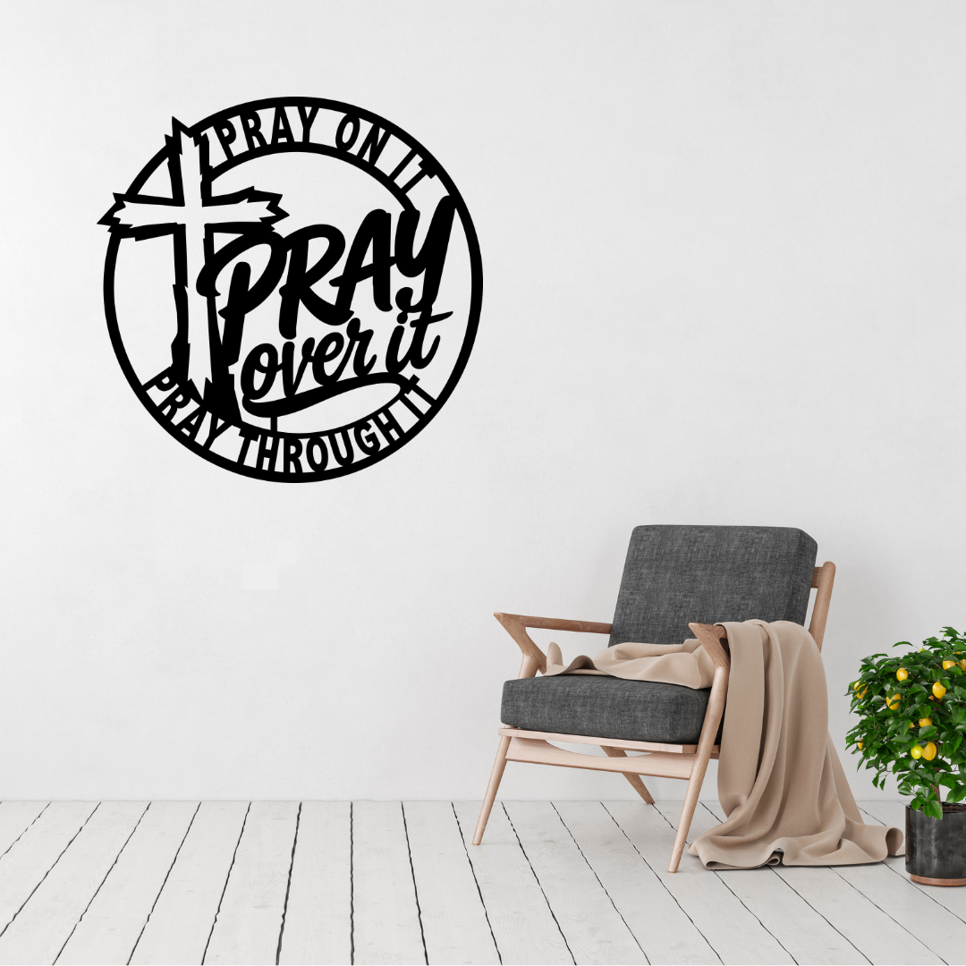 Pray on it pray over it pray through it metal wall art displayed above a contemporary chair