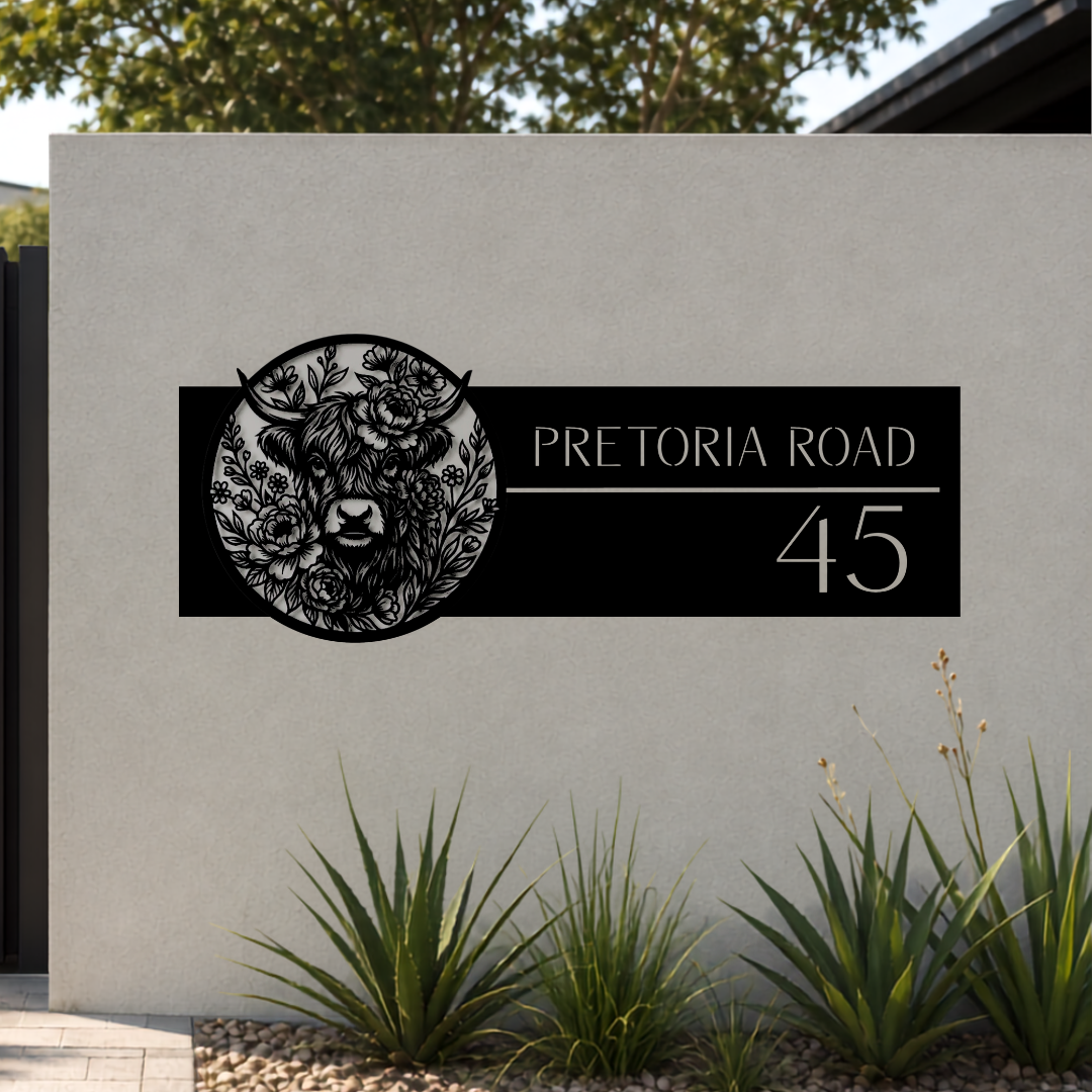 Pretoria Road Highland Cow personalised metal house number sign installed on a modern rendered entrance wall.