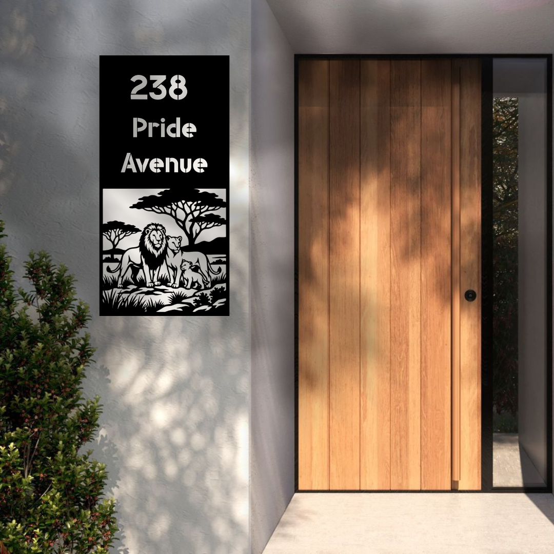 Pride Avenue Lion Family custom vertical metal house number sign installed beside a modern wooden front door on a rendered exterior wall.