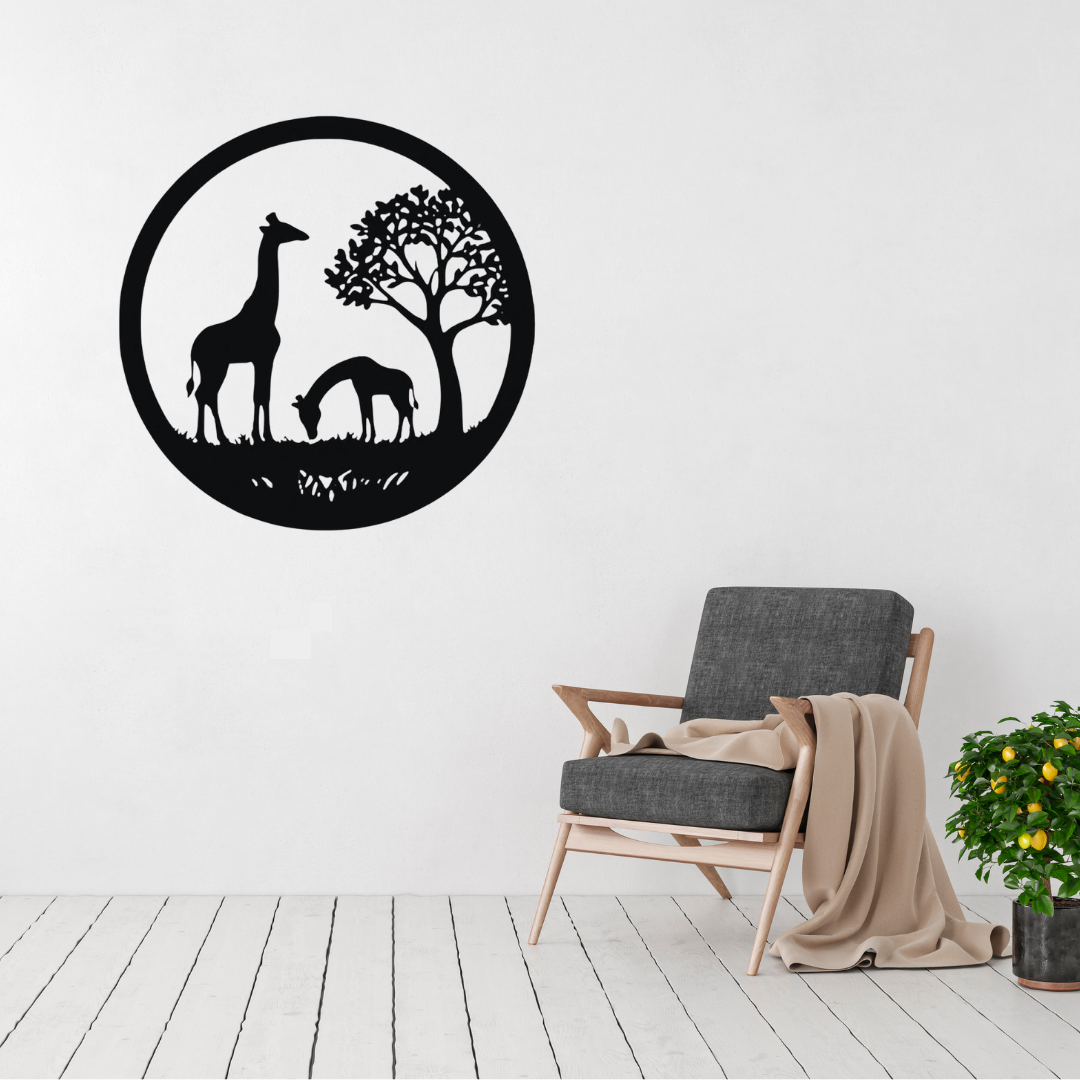 Savanna Grace | Giraffe Family Metal Wall Art displayed above a modern grey accent chair, featuring an elegant giraffe and calf beneath an African tree in a circular black metal wall art design inspired by the African savanna.