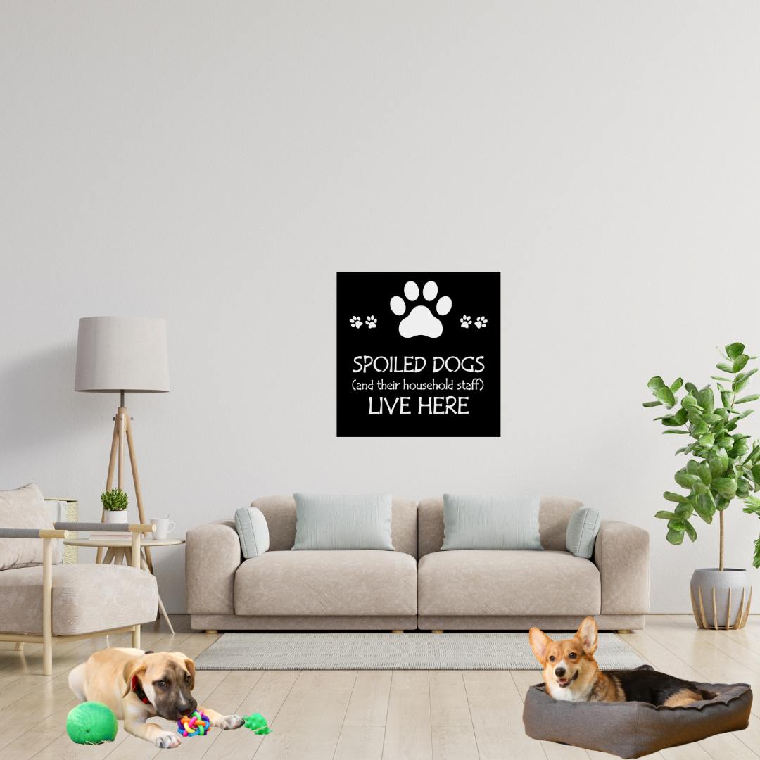 Spoiled Dogs Live Here metal wall sign displayed above a sofa in a pet-friendly living room with two dogs.