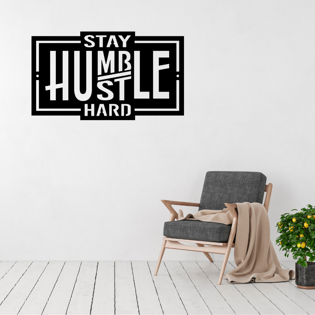 Stay Humble Hustle Hard inspirational metal wall art displayed in a modern minimalist living room.