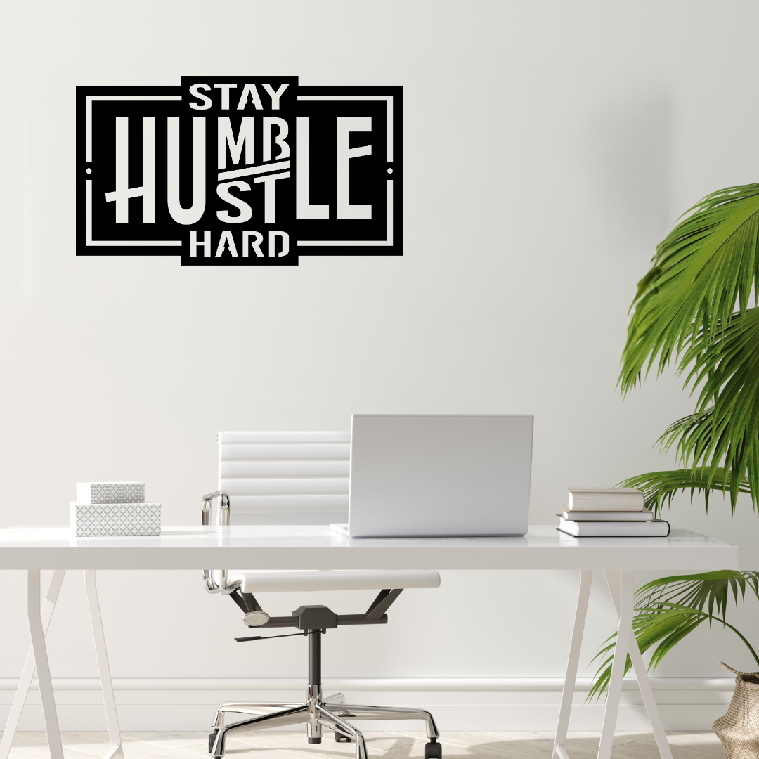 Inspirational Stay Humble metal wall art mounted above a contemporary office desk in a bright modern workspace.
