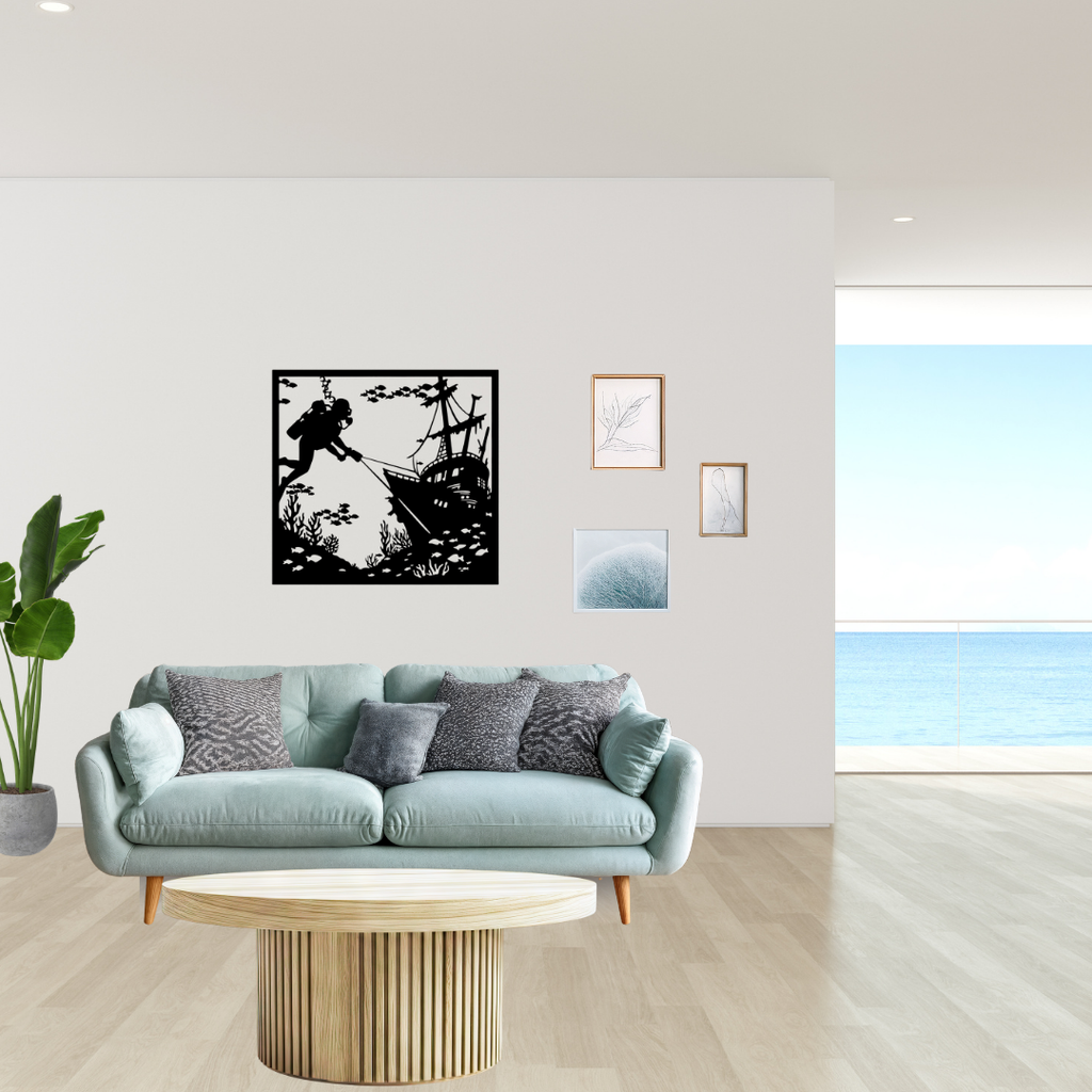 Sunken Secrets | Diver Shipwreck Metal Wall Art displayed above a modern sofa, featuring a scuba diver exploring a shipwreck beneath the ocean with coral reefs and fish in a square black metal wall art design