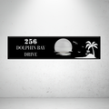 Metal house number sign with sunset and palm tree design on a grey background