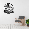 Sunset Beach | Coastal Metal Wall Art displayed in a modern living room, featuring a tranquil tropical shoreline with palm trees, an ocean sunset and calm coastal waters in an elegant circular black metal wall art design.