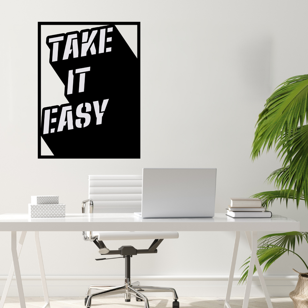 Take It Easy retro metal wall art mounted above a contemporary home office desk with minimalist décor.