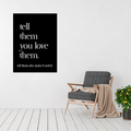 Tell Them You Love Them metal wall art displayed above a modern accent chair in a bright contemporary living room.