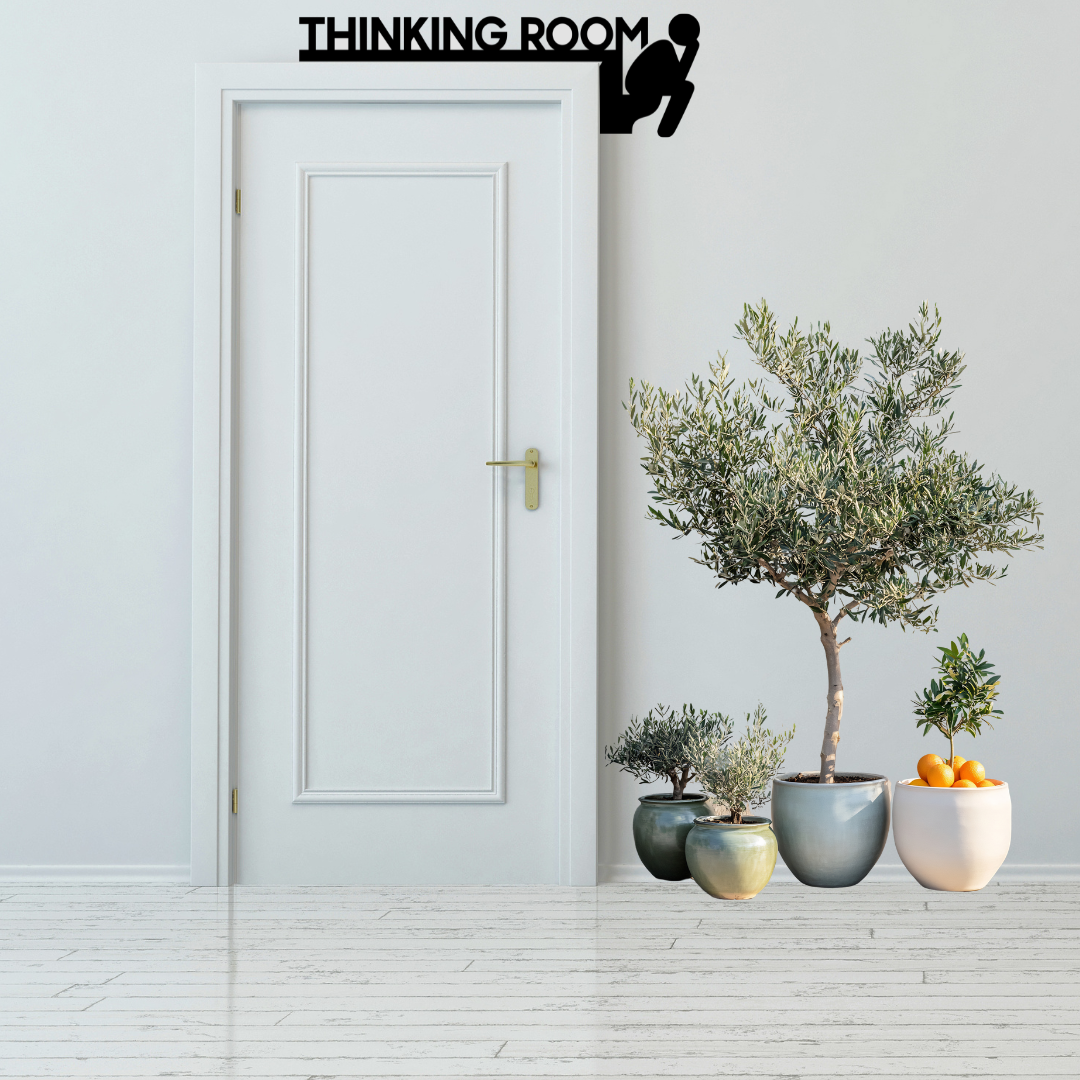 Thinking Room Humorous Bathroom Door Sign mounted above a modern white bathroom door.