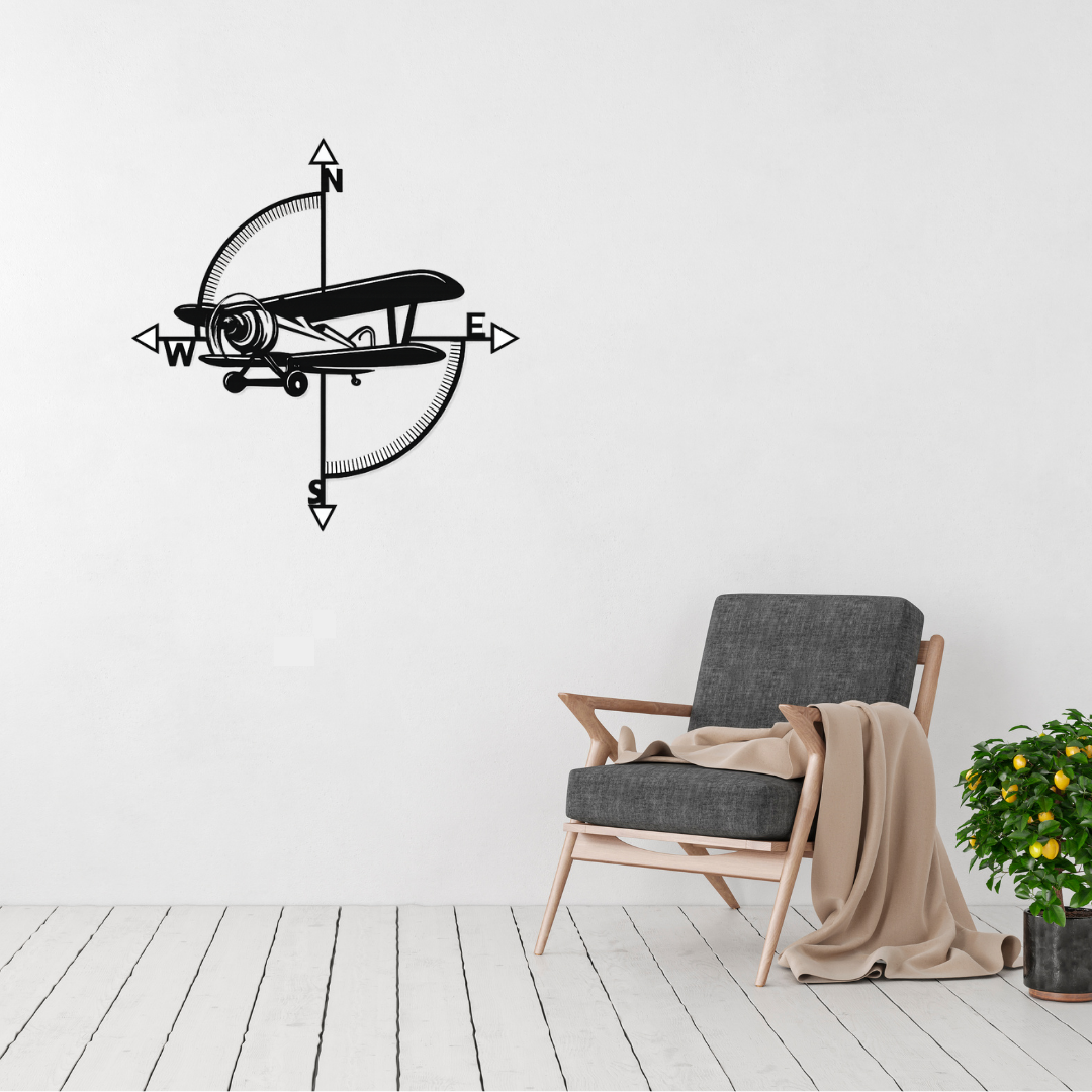 Vintage airplane compass metal wall art displayed on a modern white wall above a lounge chair, creating a timeless aviation-inspired feature.