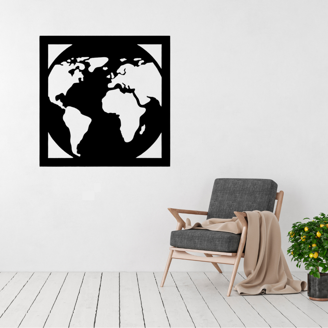 Wanderlust World | World Map Metal Wall Art displayed on a modern living room wall above a grey accent chair, featuring a minimalist world map within a contemporary square black metal frame.