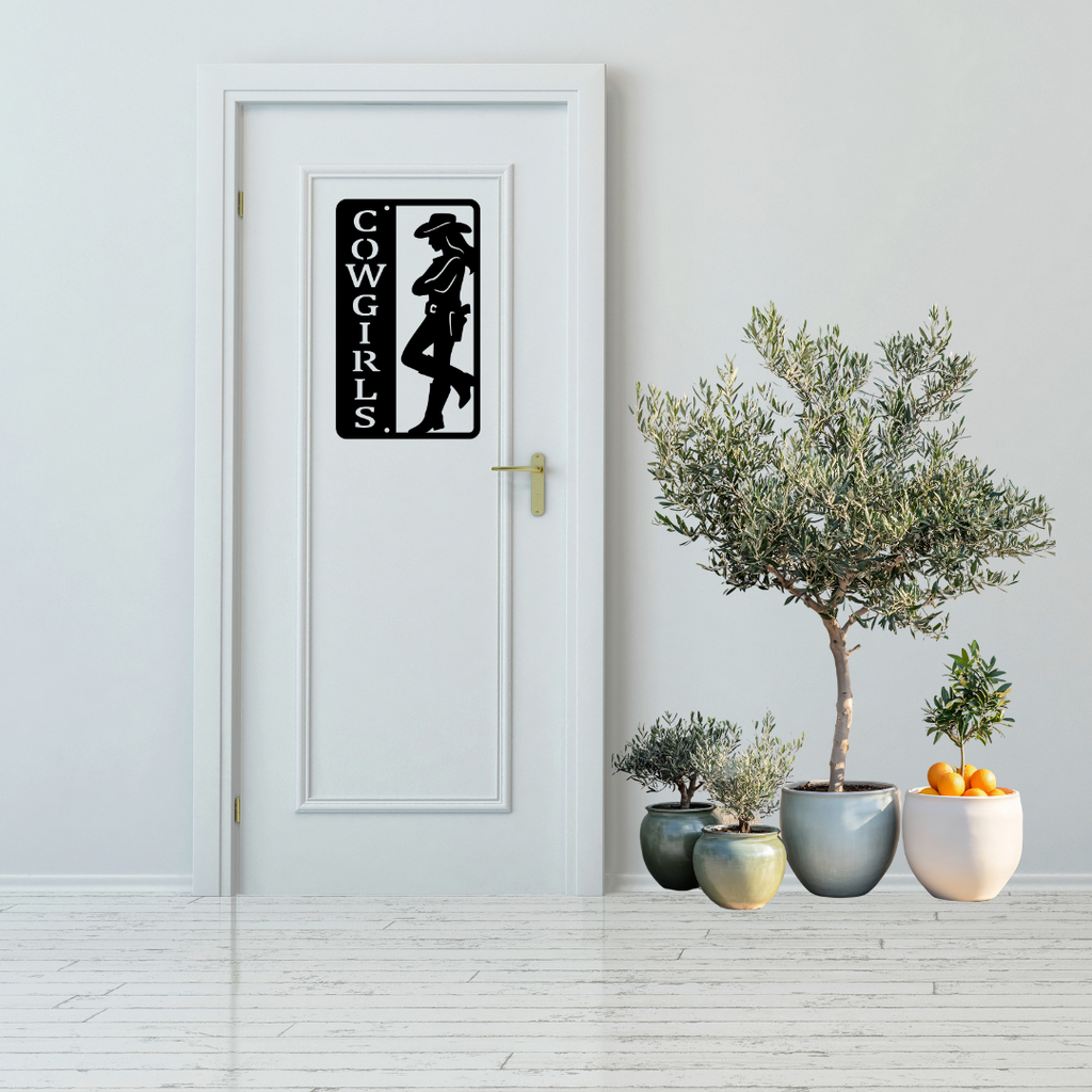 Western Charm | Cowgirls Bathroom Metal Wall Sign displayed on a modern white bathroom door.