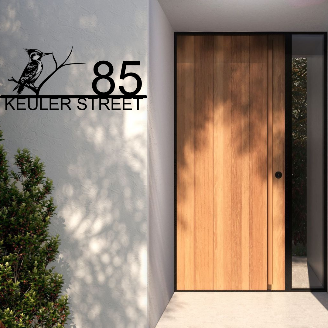 Metal house number bird-themed address sign displayed at a modern home entrance