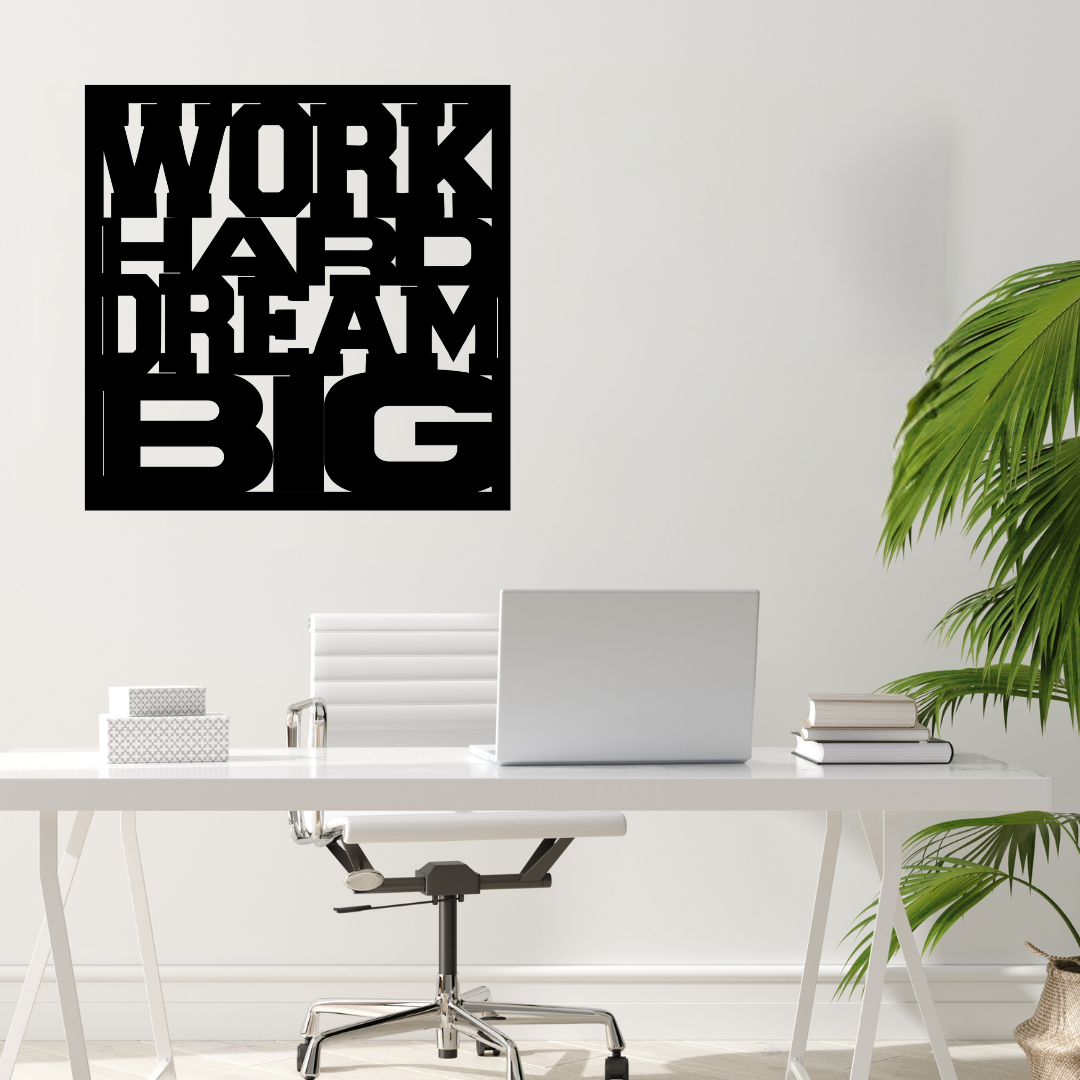 Work Hard Dream Big inspirational metal wall art mounted above a minimalist office desk in a modern workspace.
